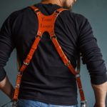 Handmade leather narrow camera strap with detailed stitching, designed for photographers and accessories enthusiasts