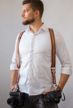 Handmade leather strap with high contrast design featuring custom logo embellishment, ideal for photographers and accessory enthusiasts