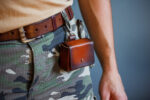 Handmade leather case for camera battery, memory card, and thermometer, designed for photographers and accessory enthusiasts