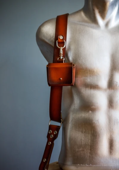 Close-up of leather pouch attached to camera strap on mannequin torso